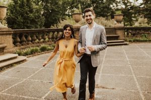 Woman in yellow shirt dress walks next to fiance