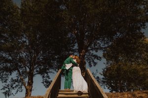 bride and groom kiss at top of stairs in rich golden light