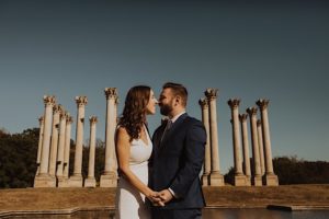 couple kiss in front of columns at national arboretum