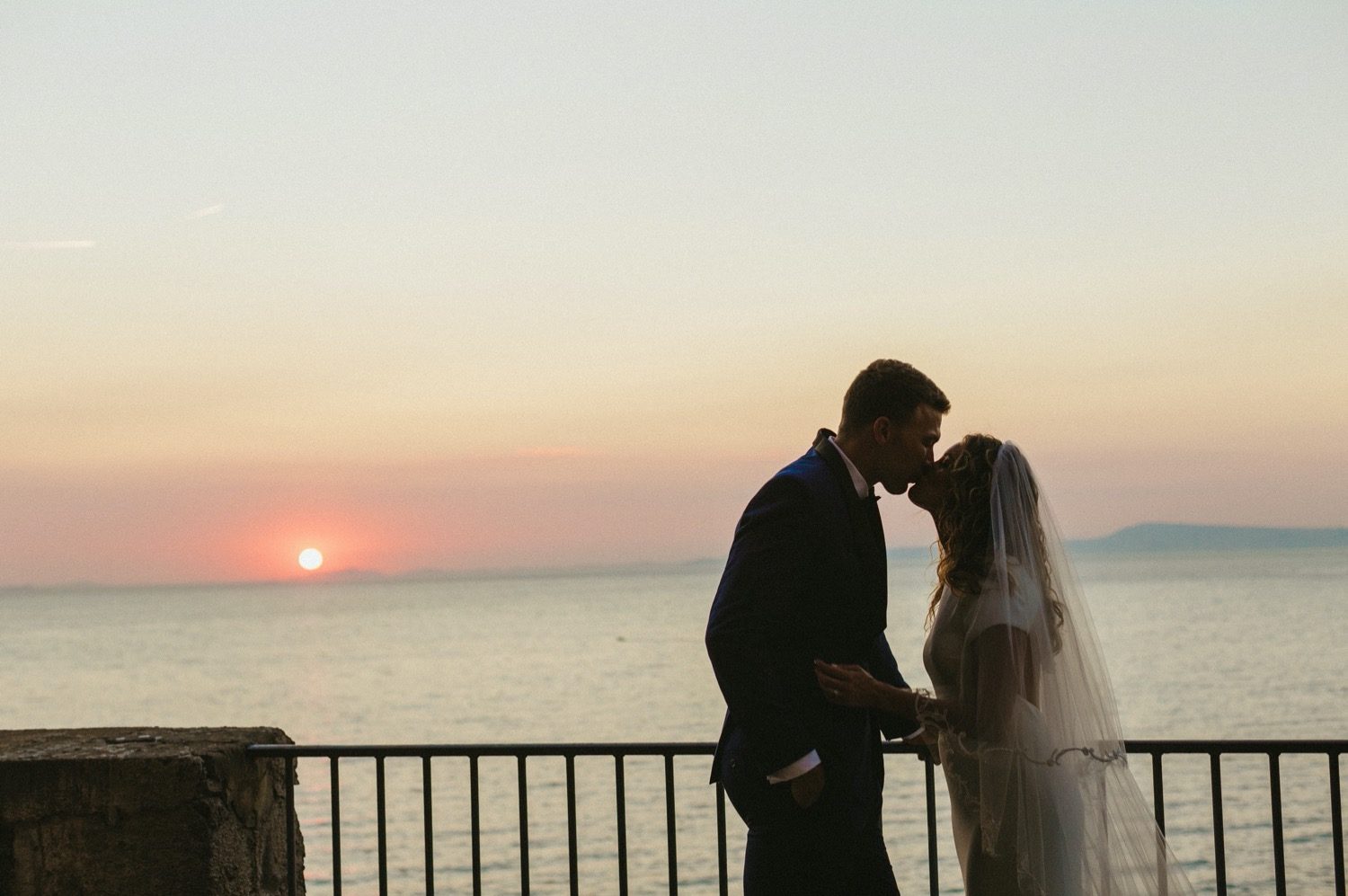 couple kiss with sun setting in background