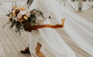 bride walks while dress and bouquet flow in air