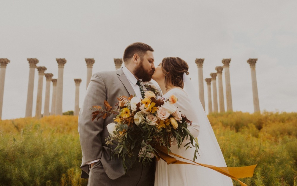 newlyweds kiss with national arboretum columns in background