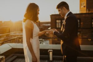 groom puts wedding ring on wife