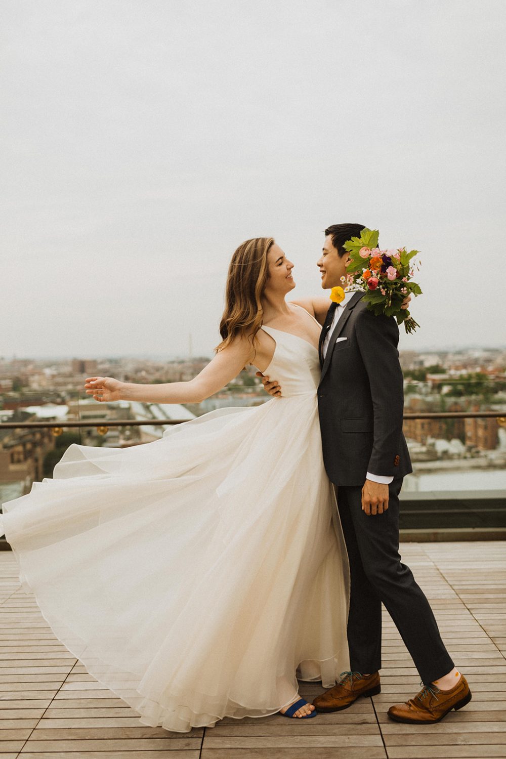 Couple embraces with flowing wedding dress on the line dc hotel rooftop