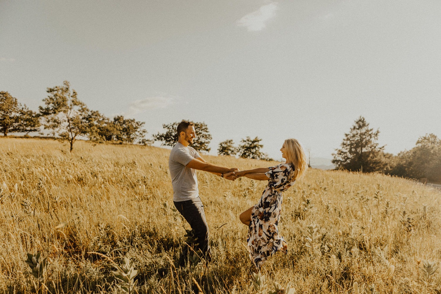 Couple twirls in field at Shenandoah National Park adventure session