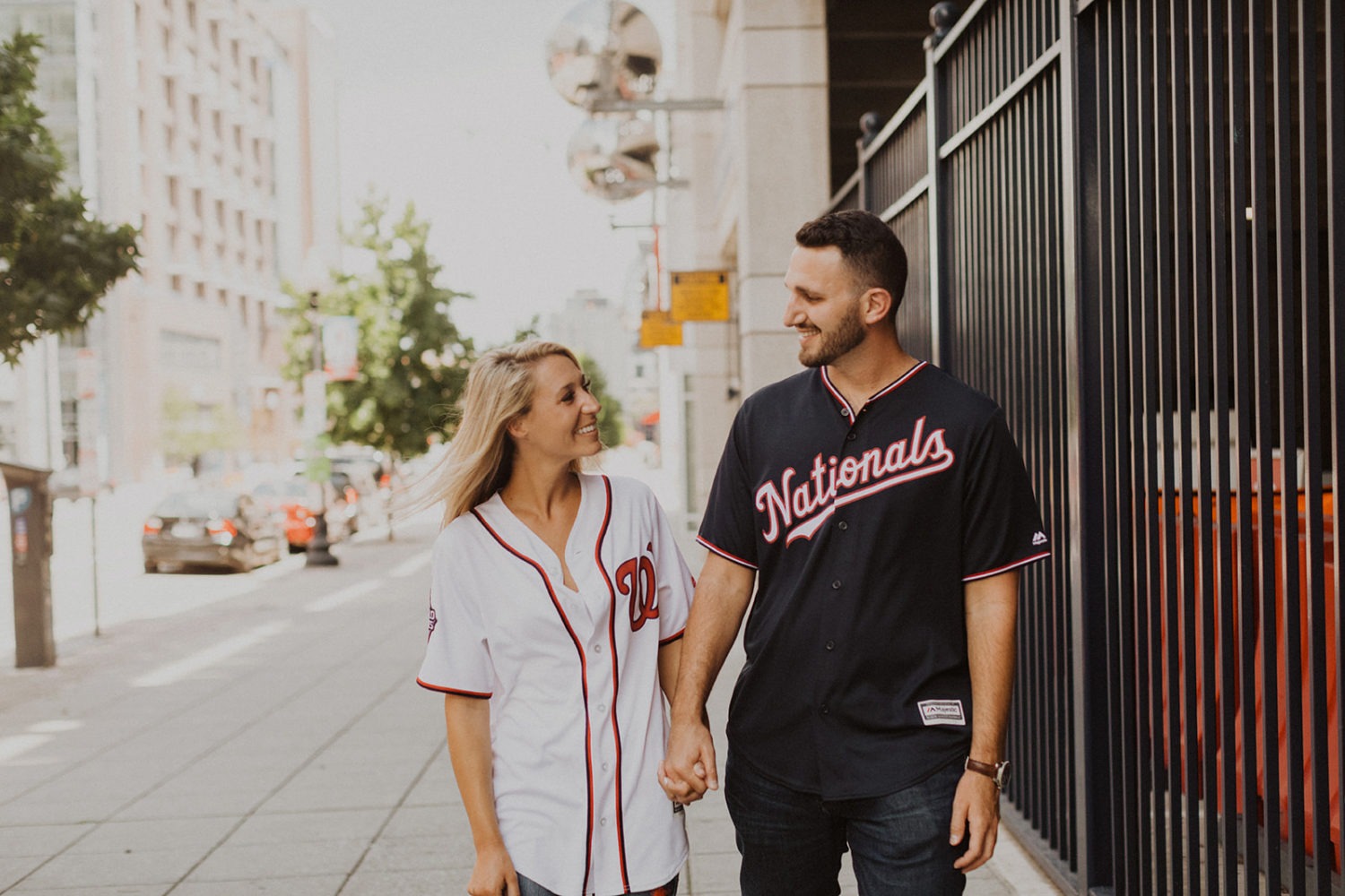 Couple holds hands at Nationals stadium adventure session