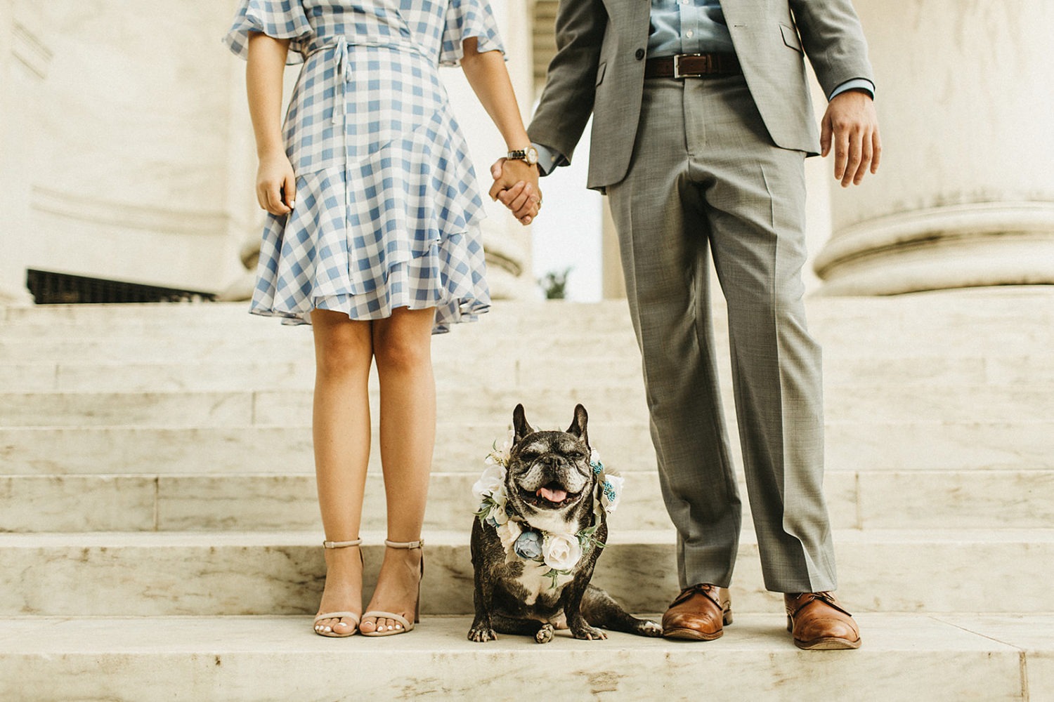 Couple holds hands with dog at Jefferson Memorial