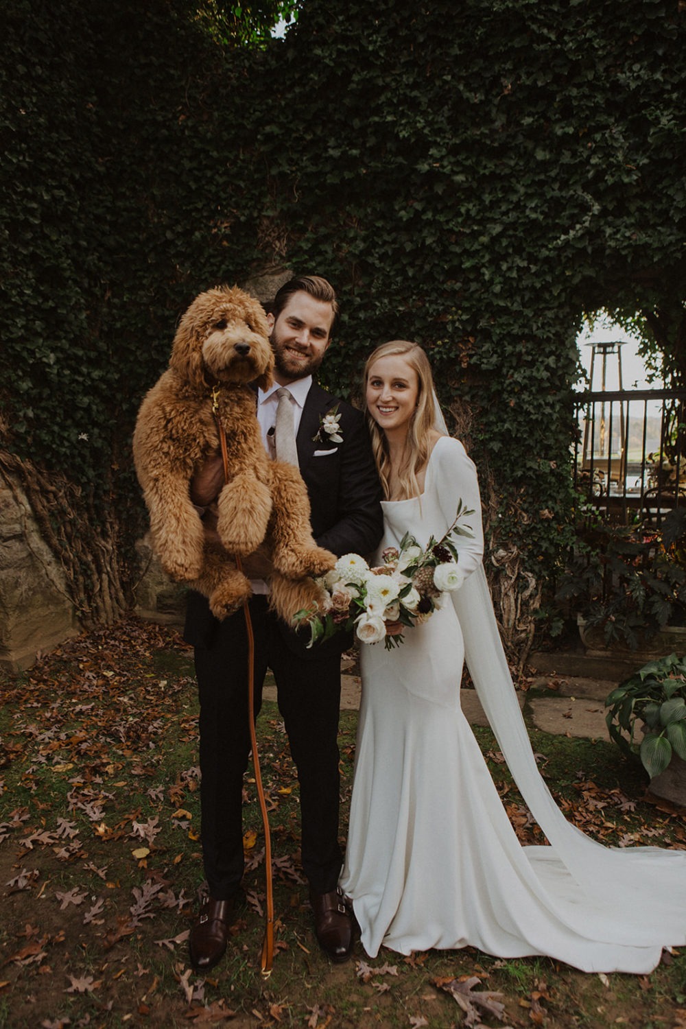 Couple holds dog at wedding