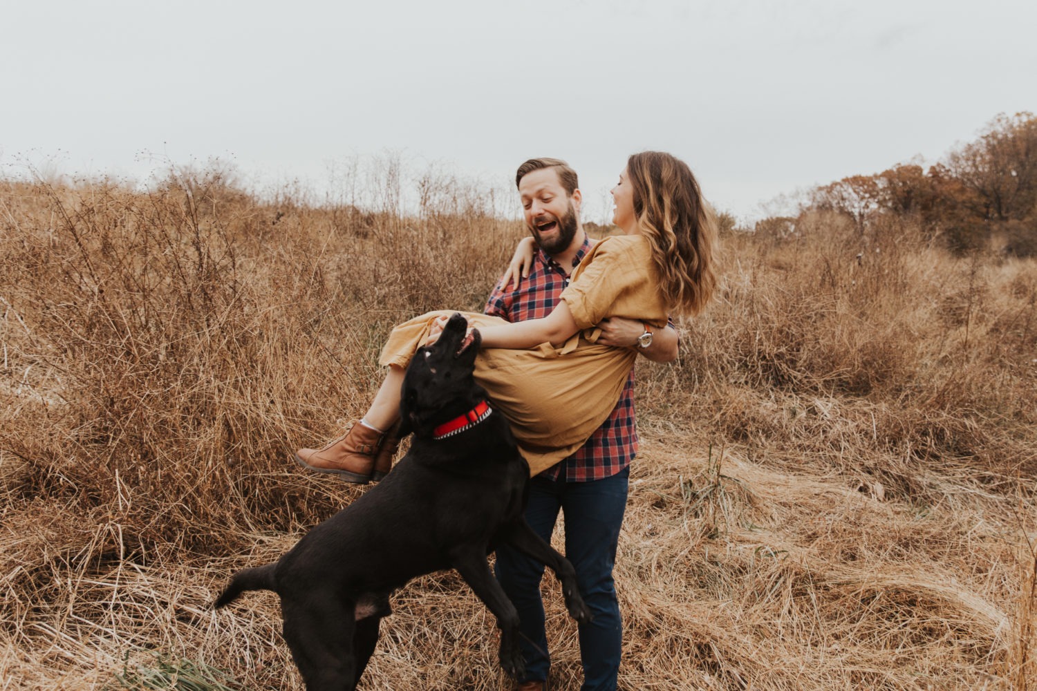 Dog jumps on couple in field engagement session
