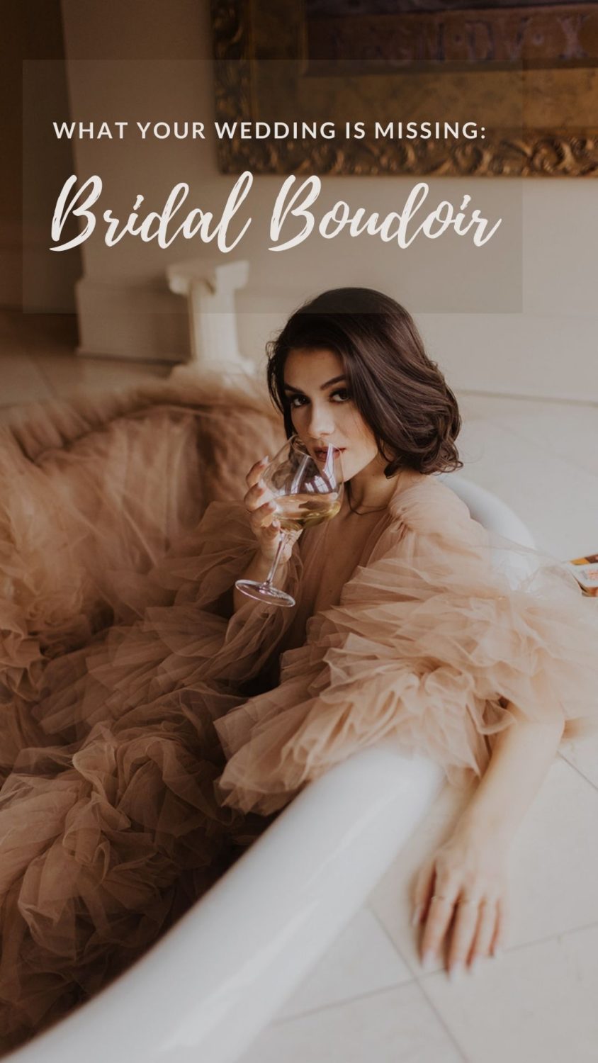 Bride sits in bathtub sipping champagne wearing wedding lingerie.
