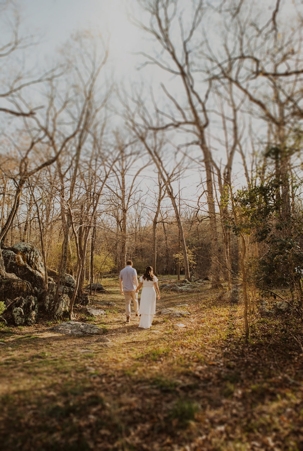Couple walks holding hands at Great Falls Park elopement
