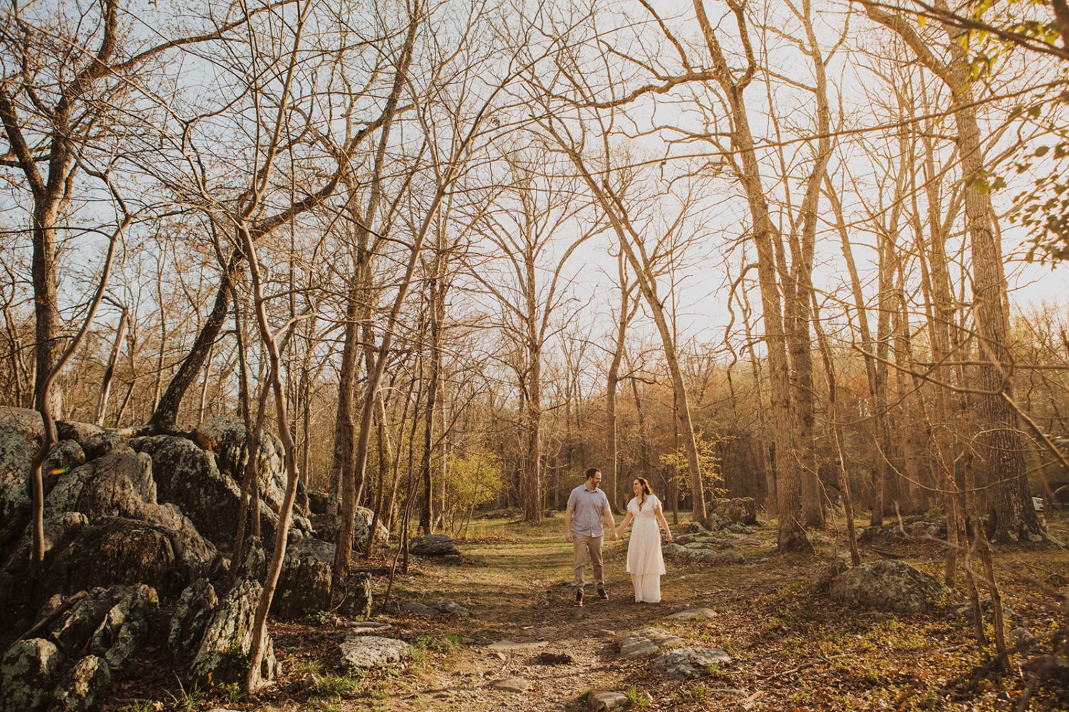Couple walks holding hands at Great Falls Park elopement