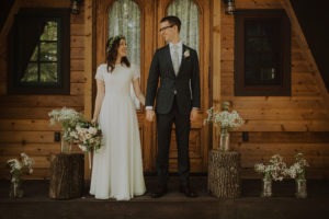 Couple elopes in front of a-frame cabin