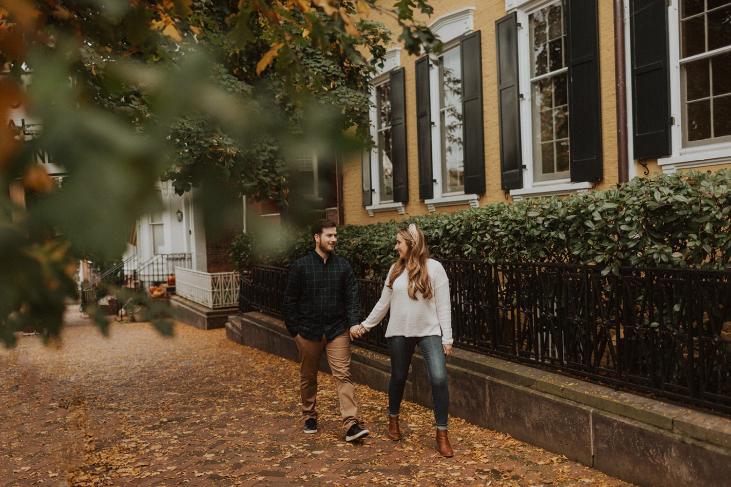 Couple walks holding hands at Georgetown engagement session