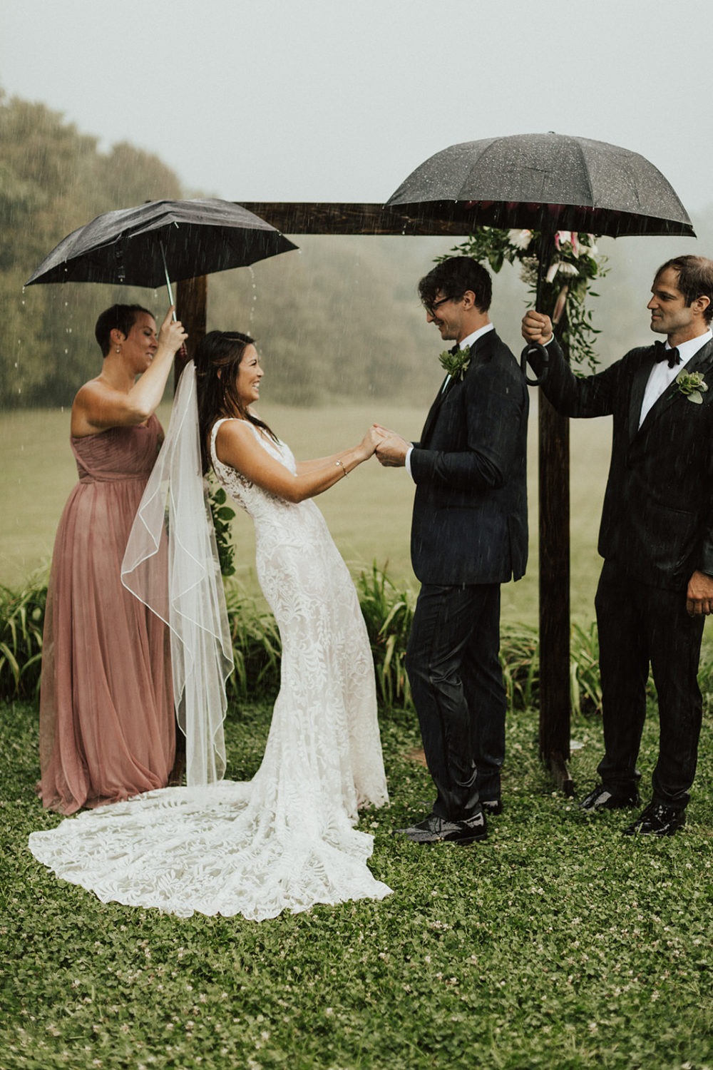 Couple exchanges vows under umbrellas at rainy wedding day