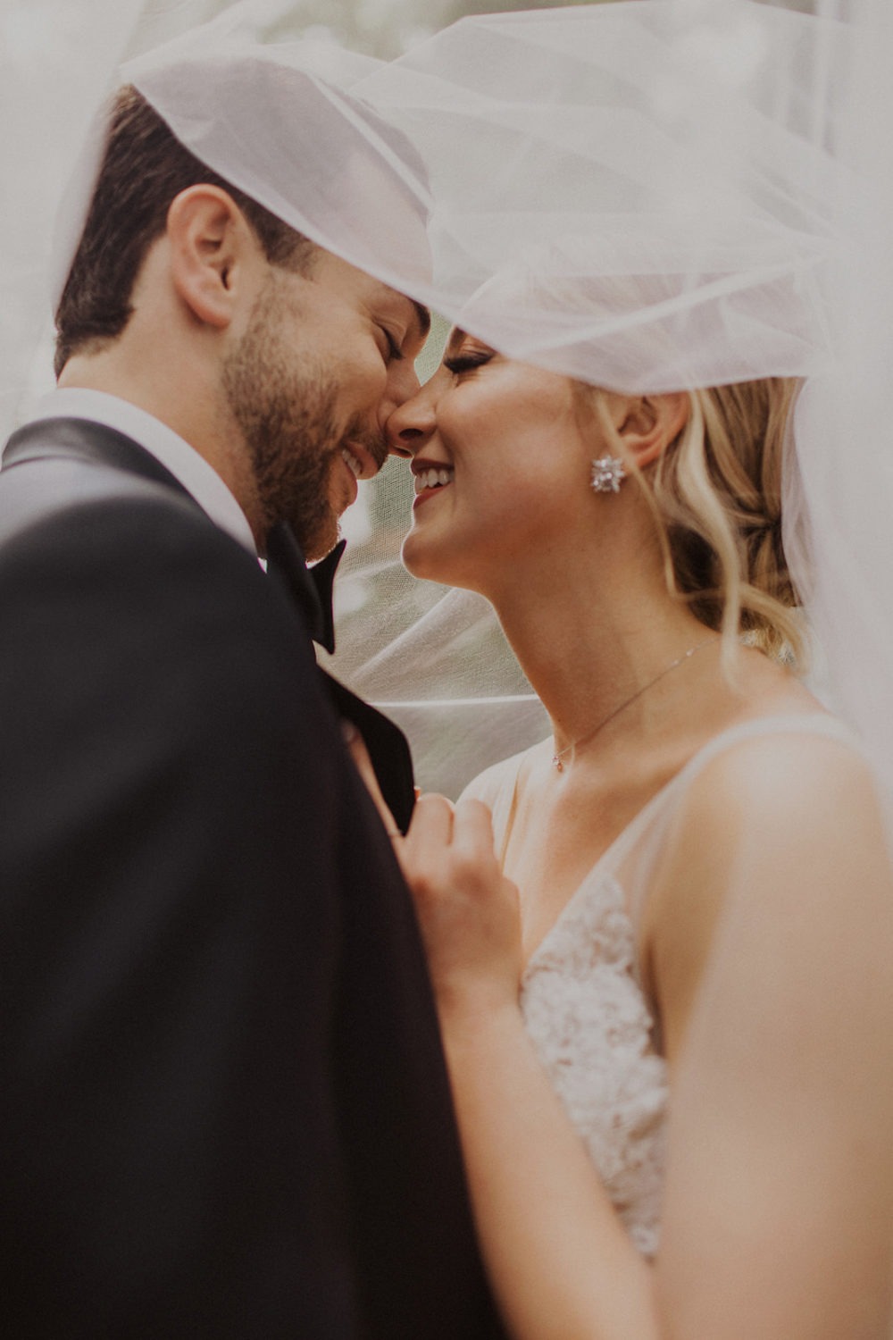 Couple kisses under veil at wedding