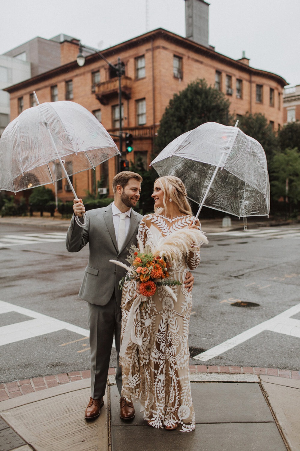 Couple stands under umbrella at rainy dc wedding