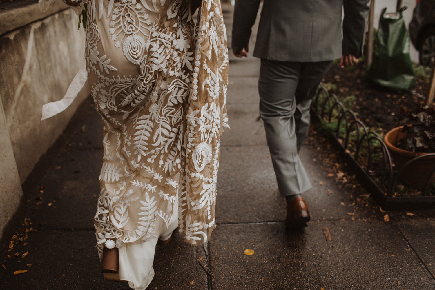 Couple walks on Washington, DC street at rainy wedding day