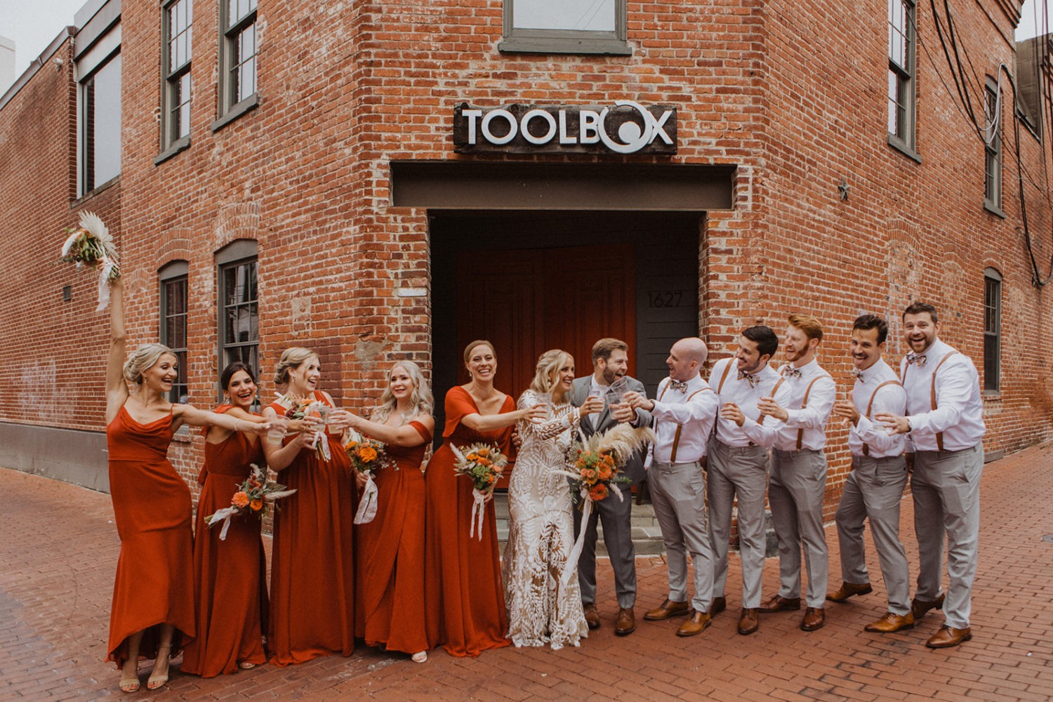 Couple cheers with wedding party at Toolbox DC wedding