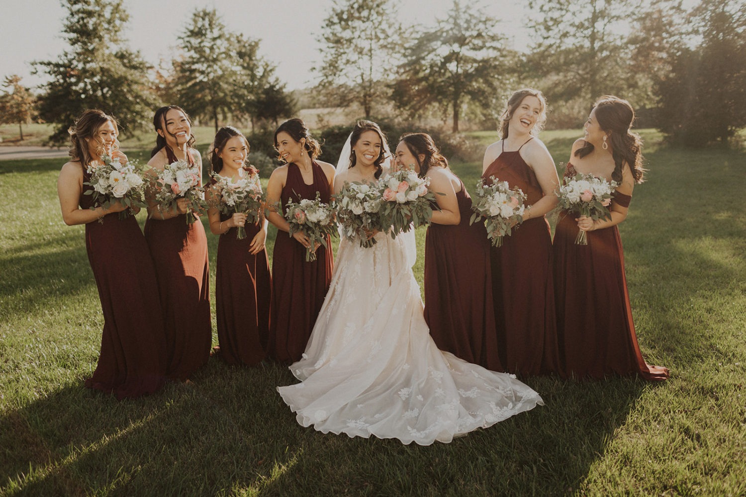 Bride and bridesmaids hold bouquets at outdoor wedding