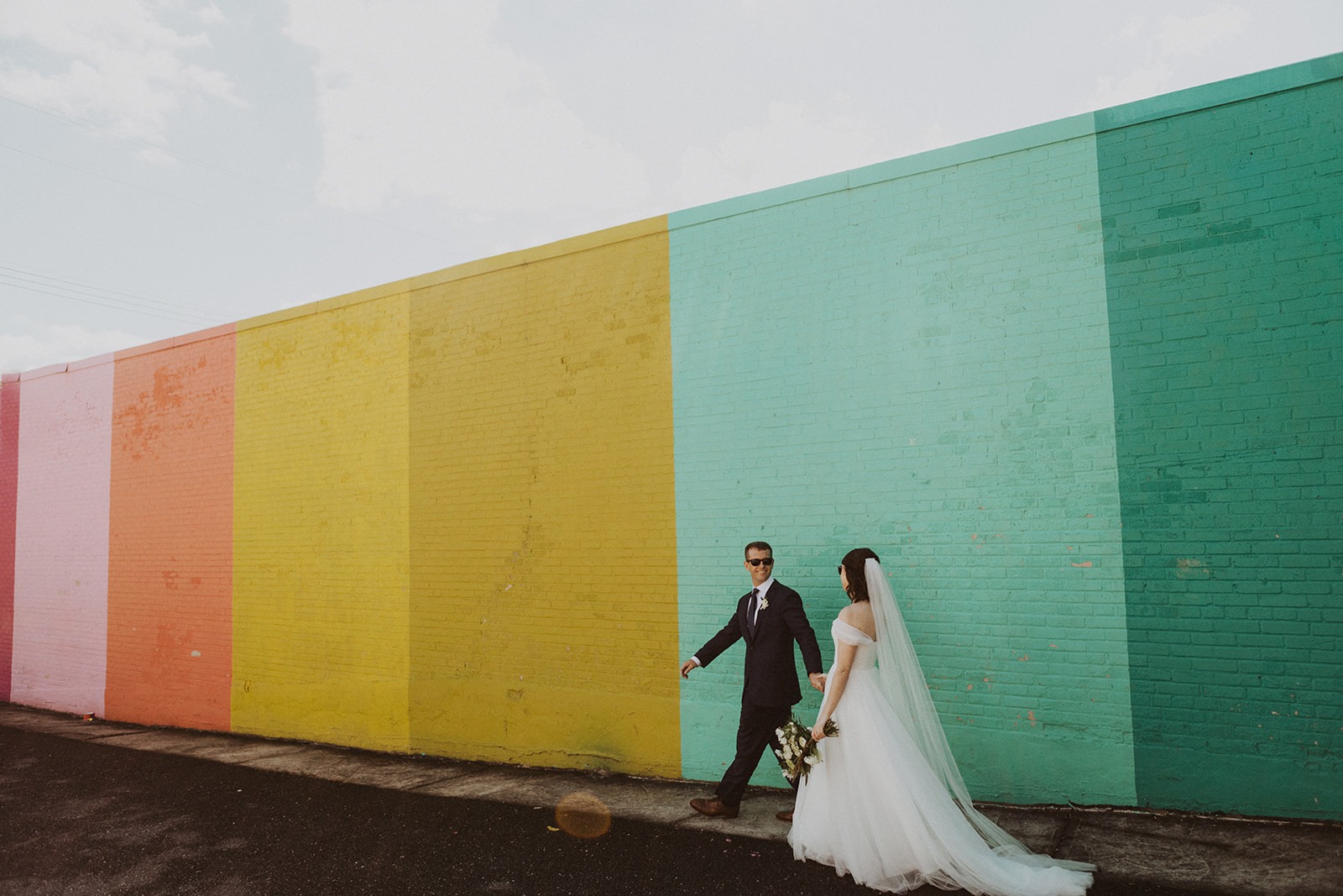 Couple walks at rainbow wall at full-day elopement