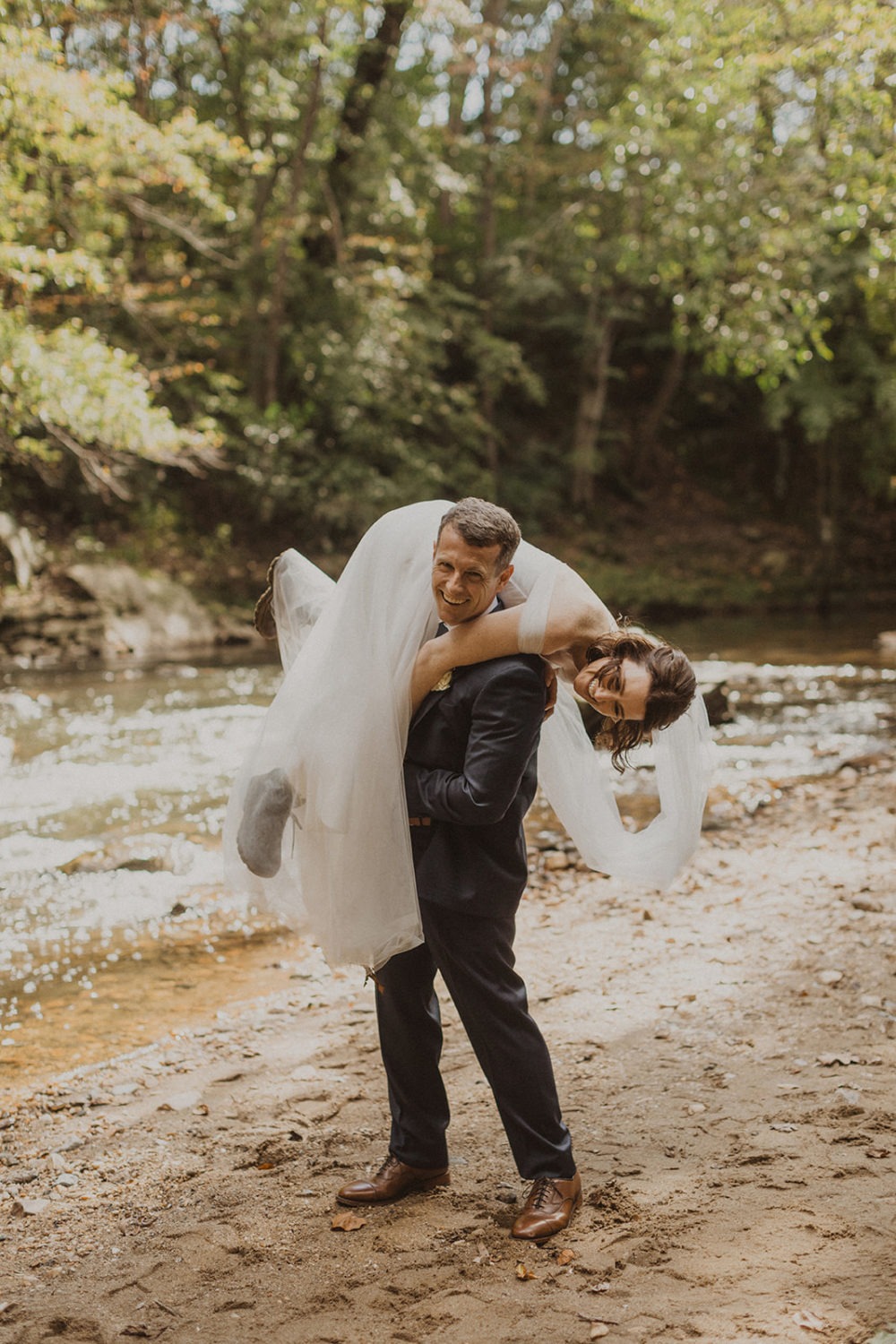 Groom carries bride at Rock Creek Park elopement