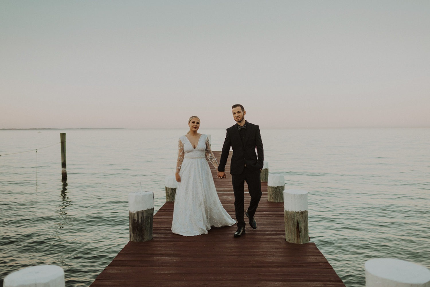 Couple walks on the pier at Celebrations At the Bay wedding venue