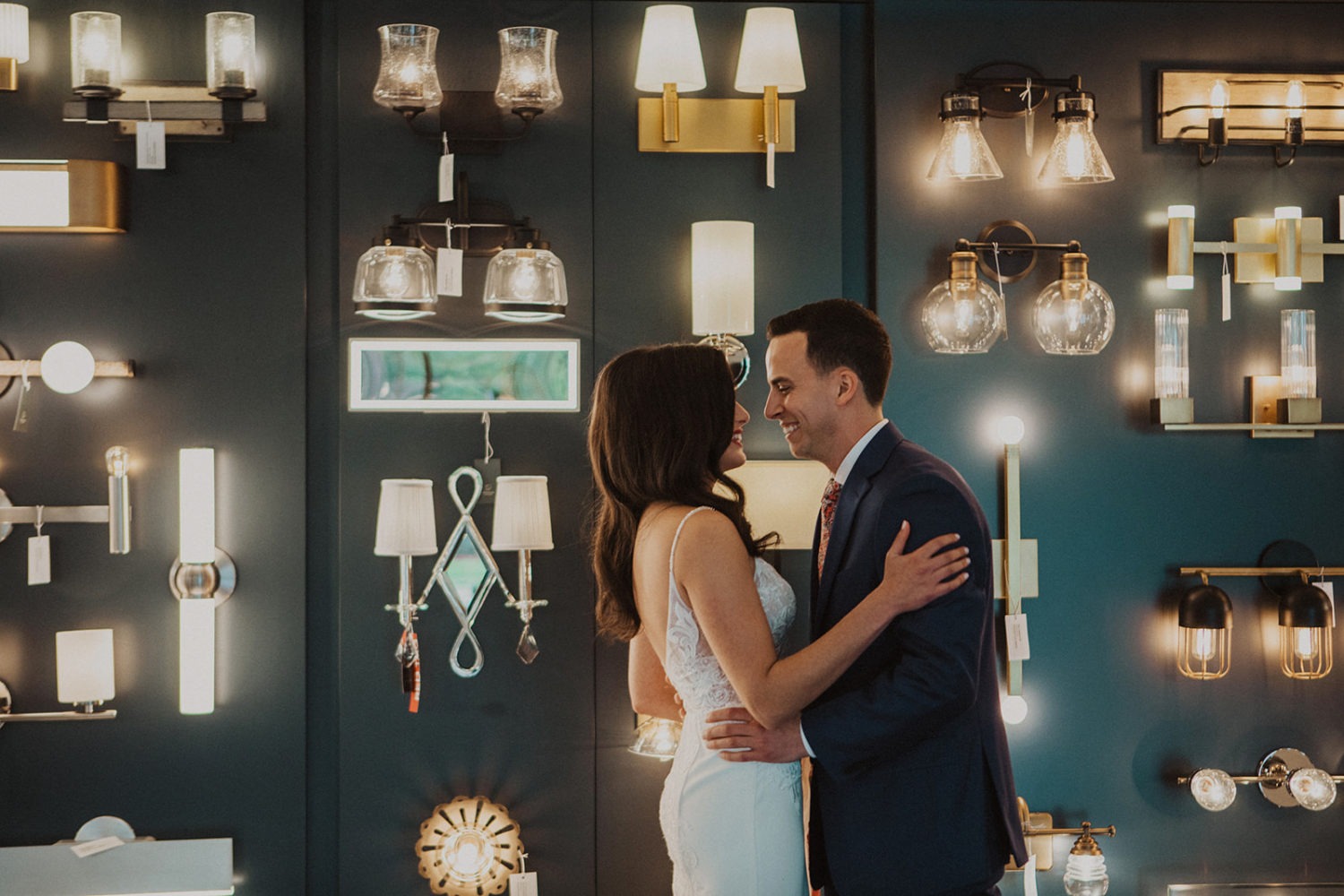 Couple embraces during wedding first look at lighting shop
