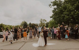 Couple cheers with guests at COVID-restricted wedding