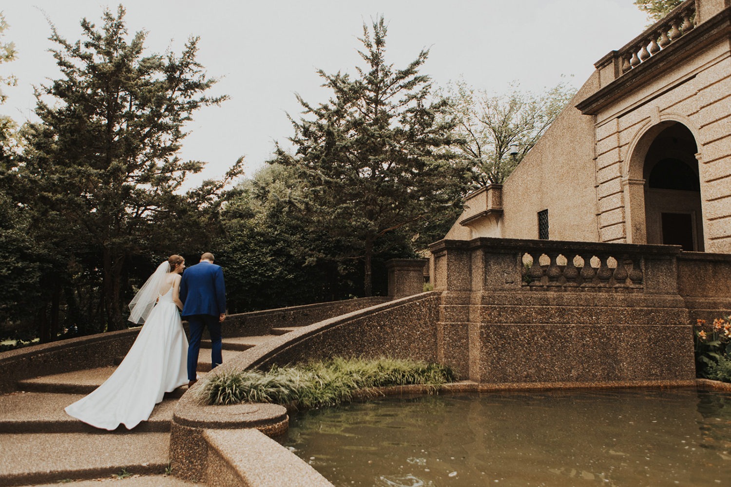 Couple walks up staircase holding hands at Meridian Hill Park DC garden wedding