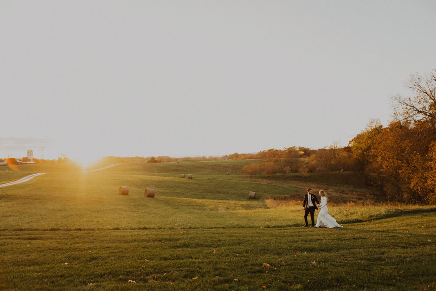 Couple walks through field at Goodstone Inn Virginia garden wedding