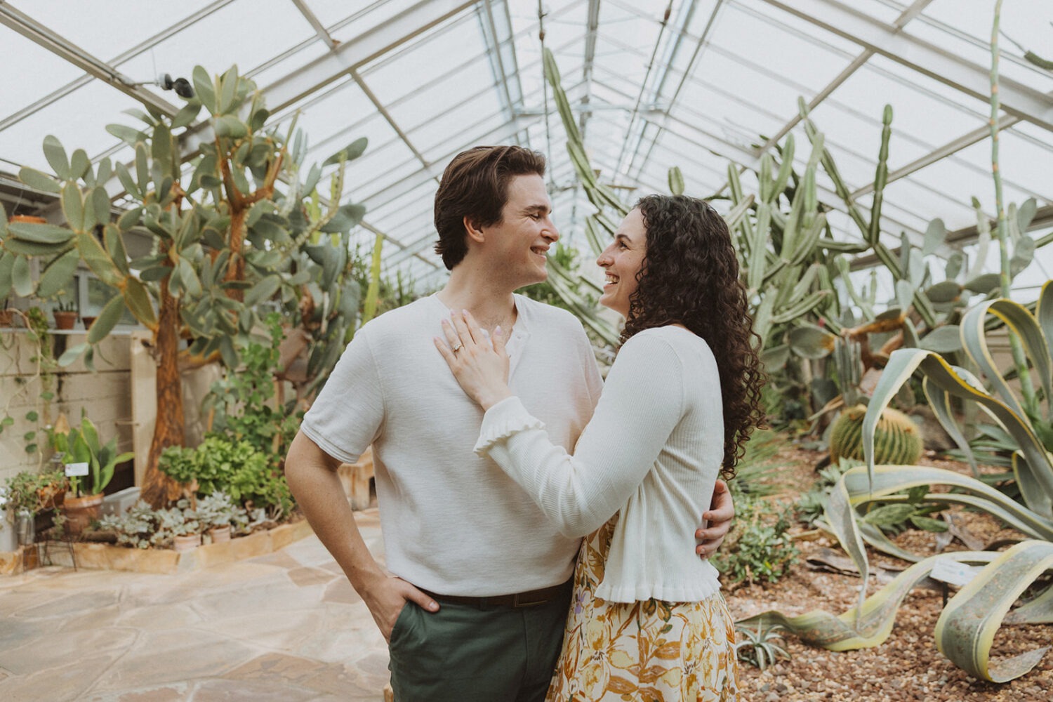 couple embrace in the middle of greenhouse