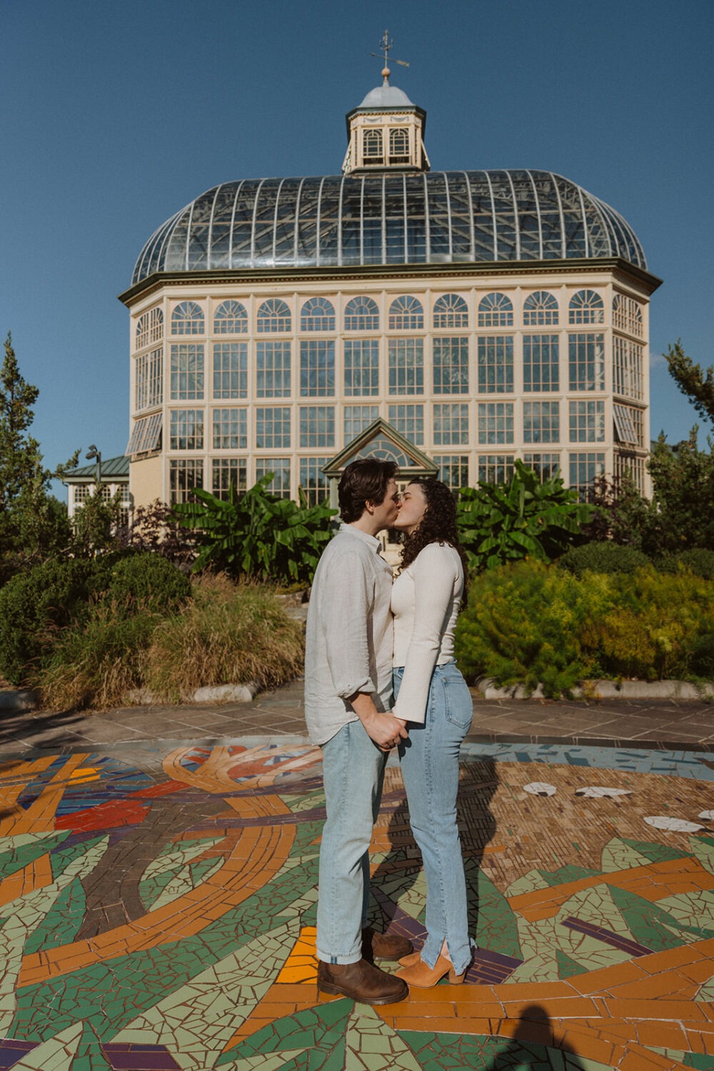 couple kiss in front of Rawlings Conservatory