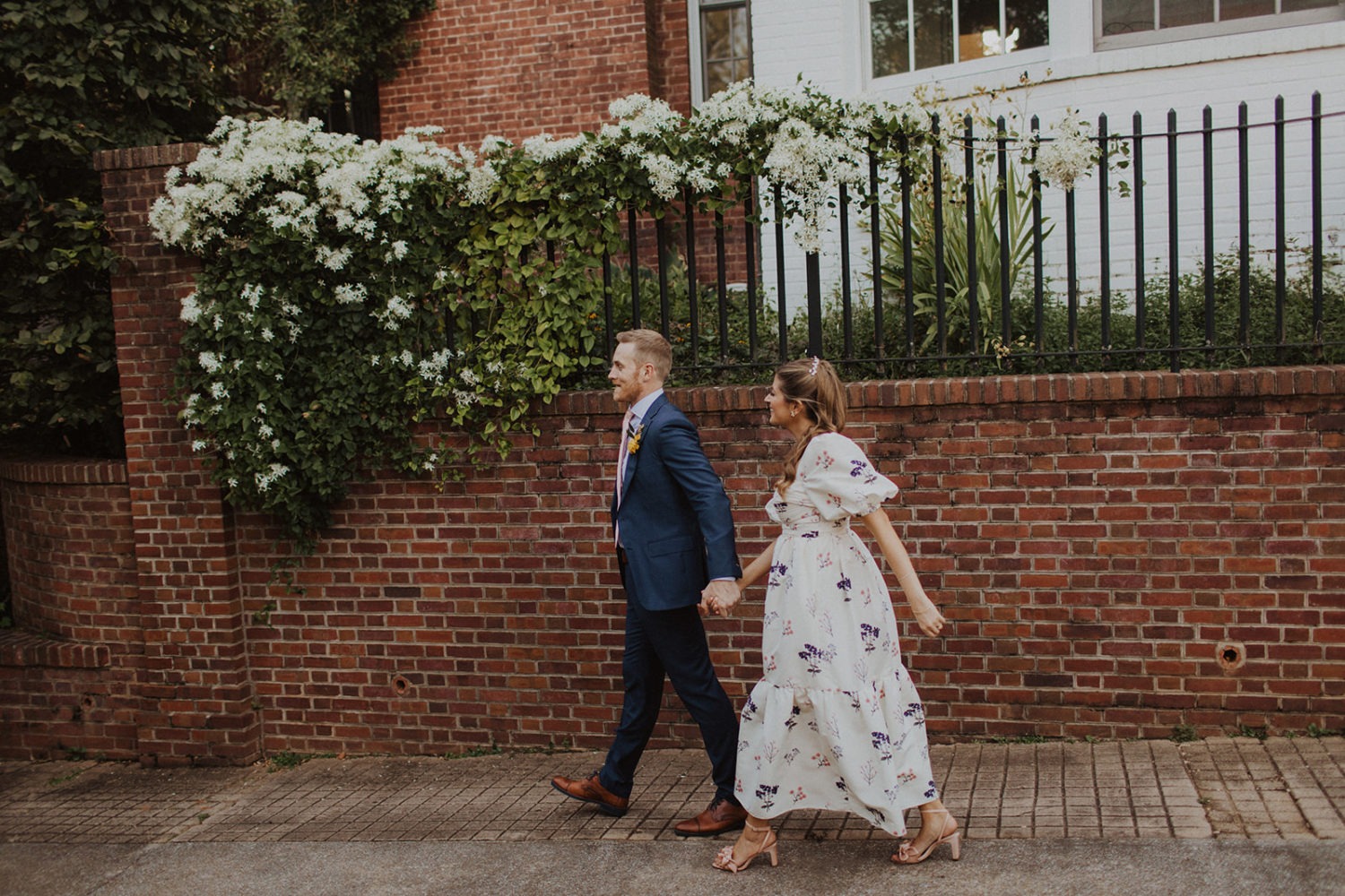 Couple walks holding hands in front of Dumbarton House DC garden wedding venue