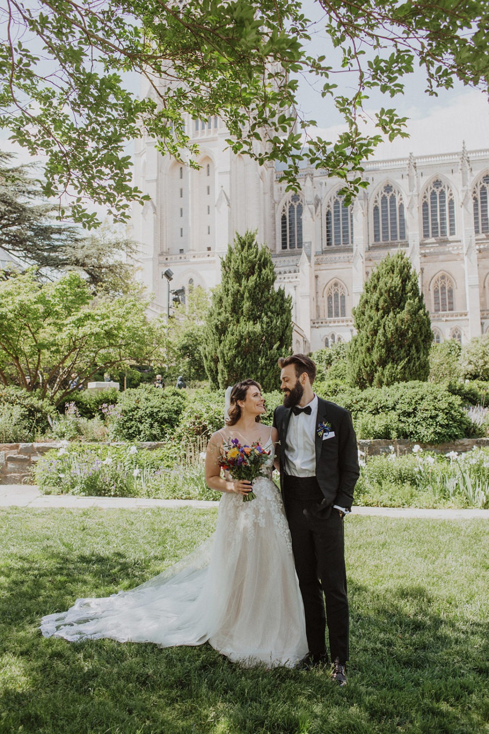 Couple stands in front National Cathedral at DC garden wedding