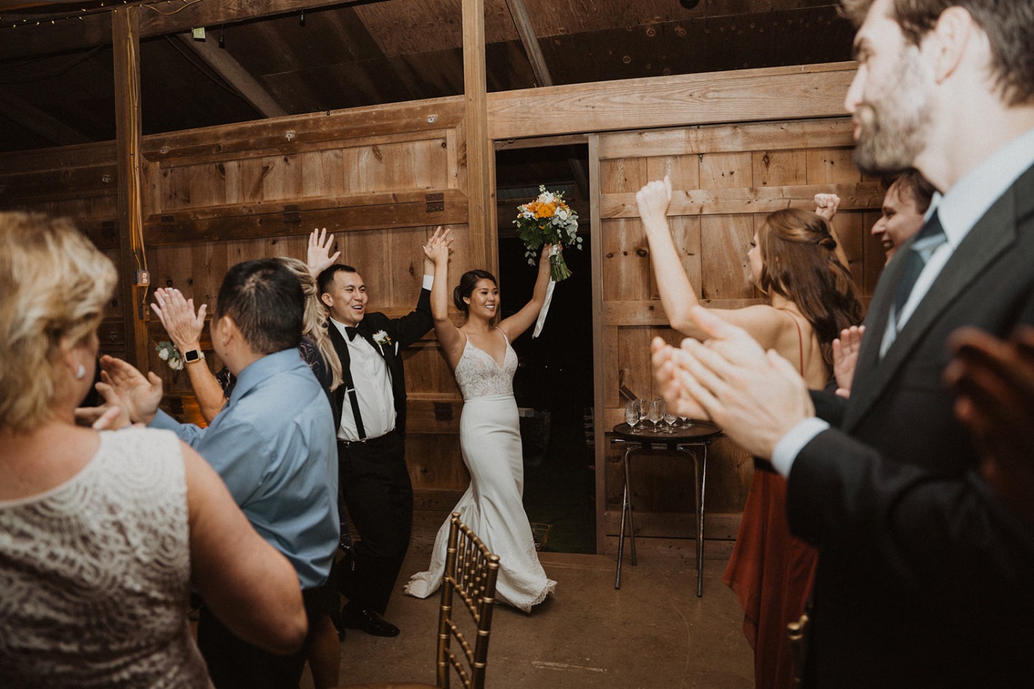 Couple enters reception at barn wedding