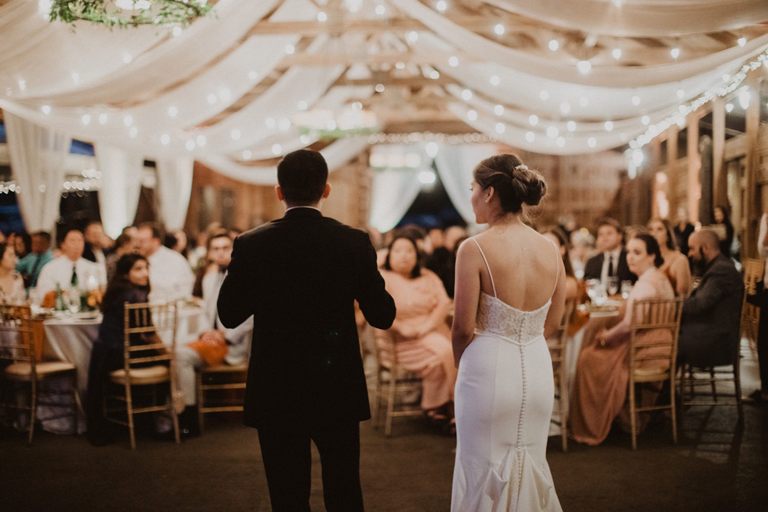 Couple speaks to guests at wedding reception