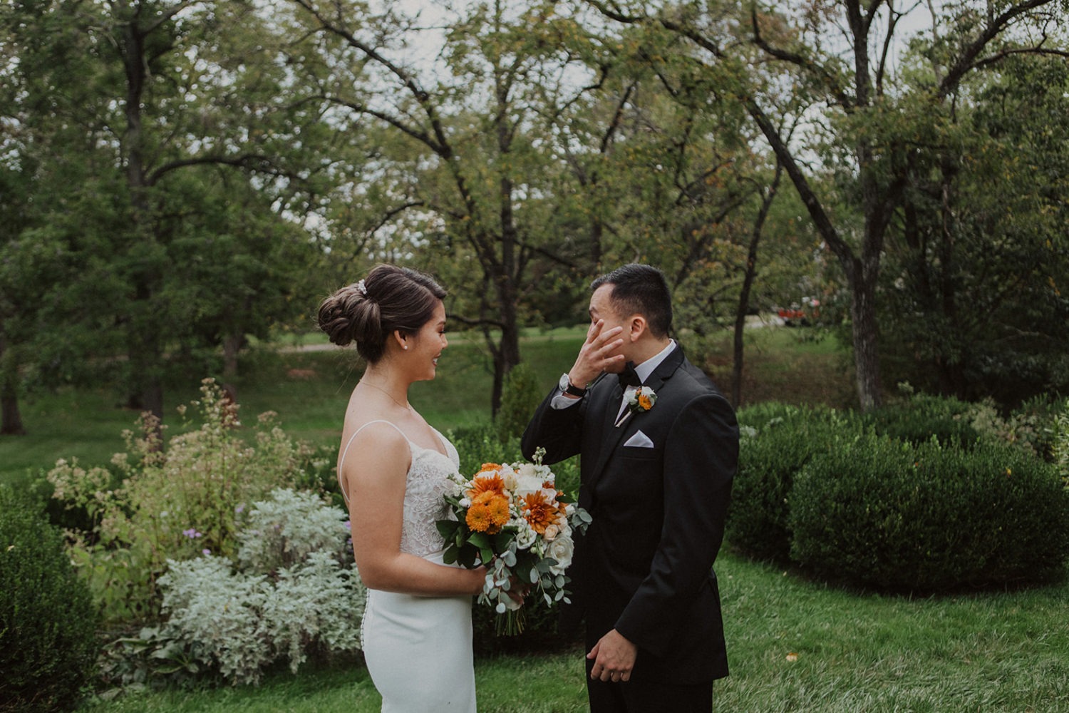 Groom wipes away tears during first look at garden wedding