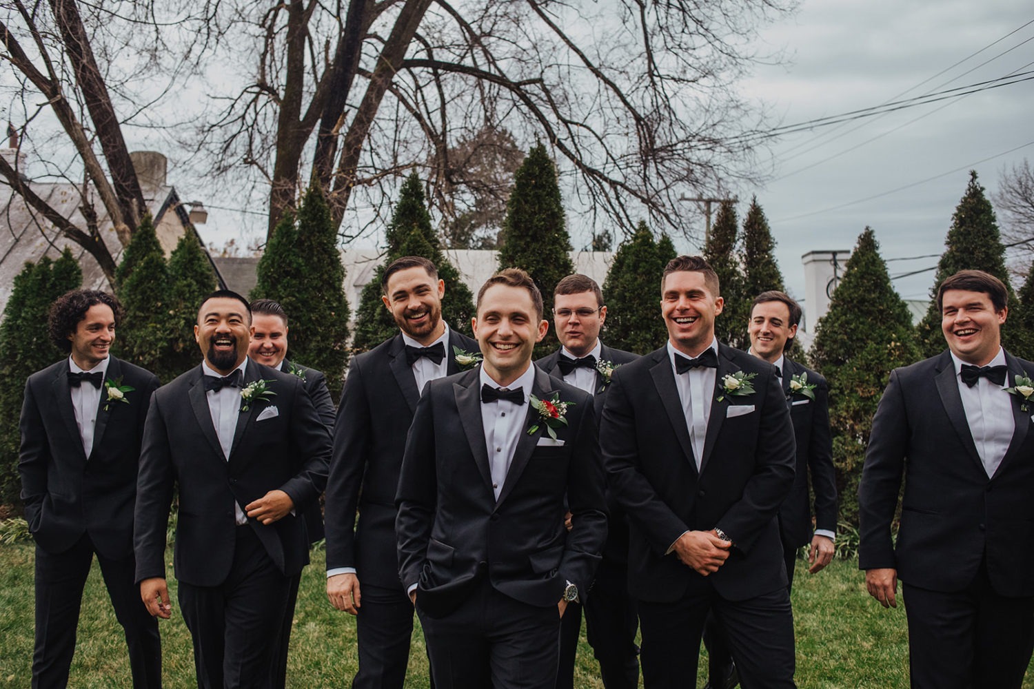 Groom walks laughing with groomsmen at red fox inn wedding