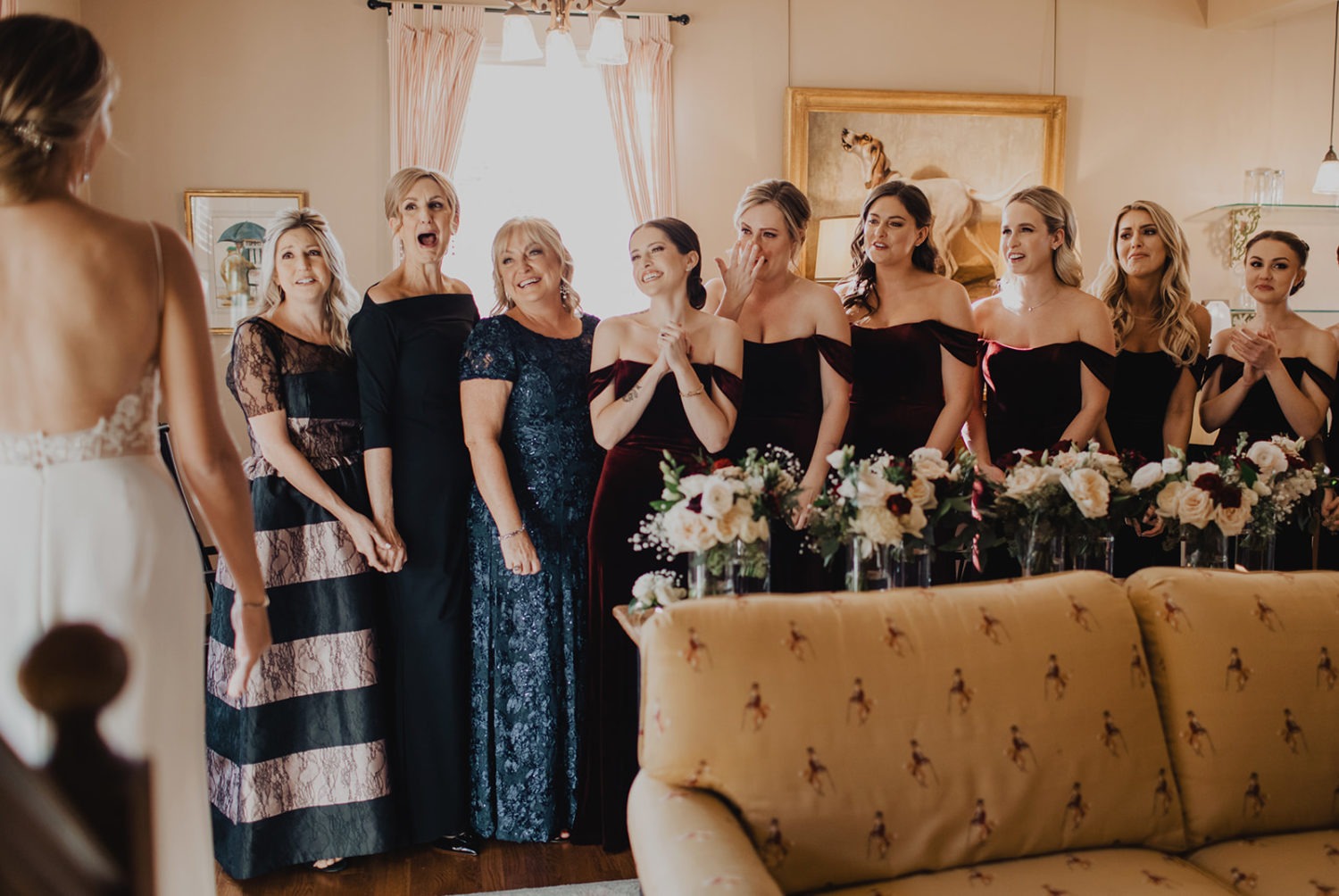 Bride reveals wedding dress to bridesmaids and moms while getting ready on the wedding morning