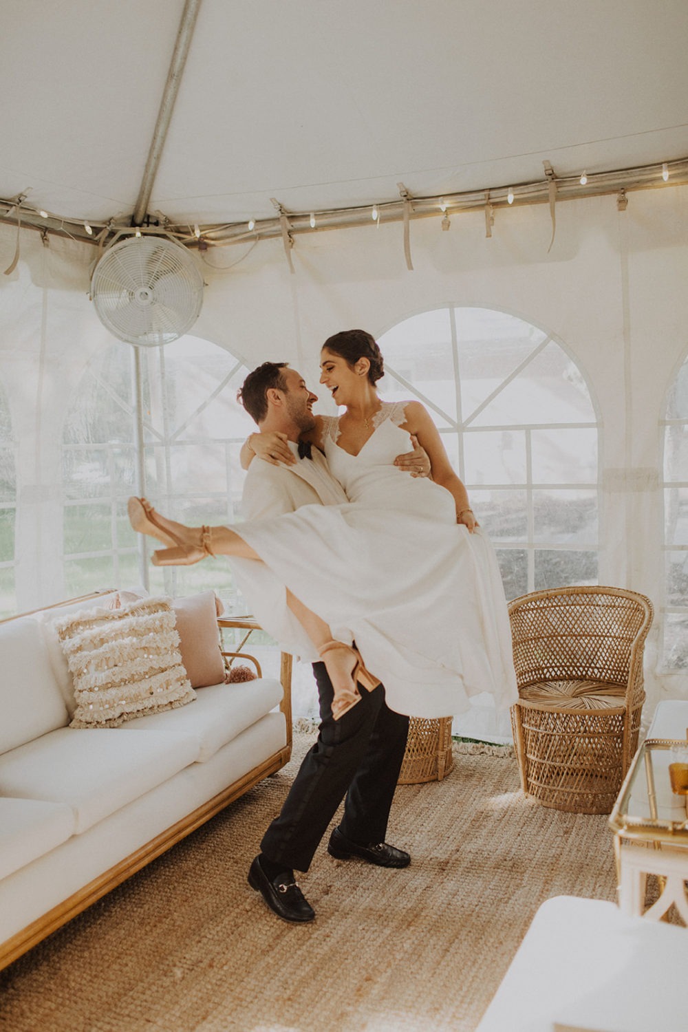 Couple embraces in reception tent at backyard wedding