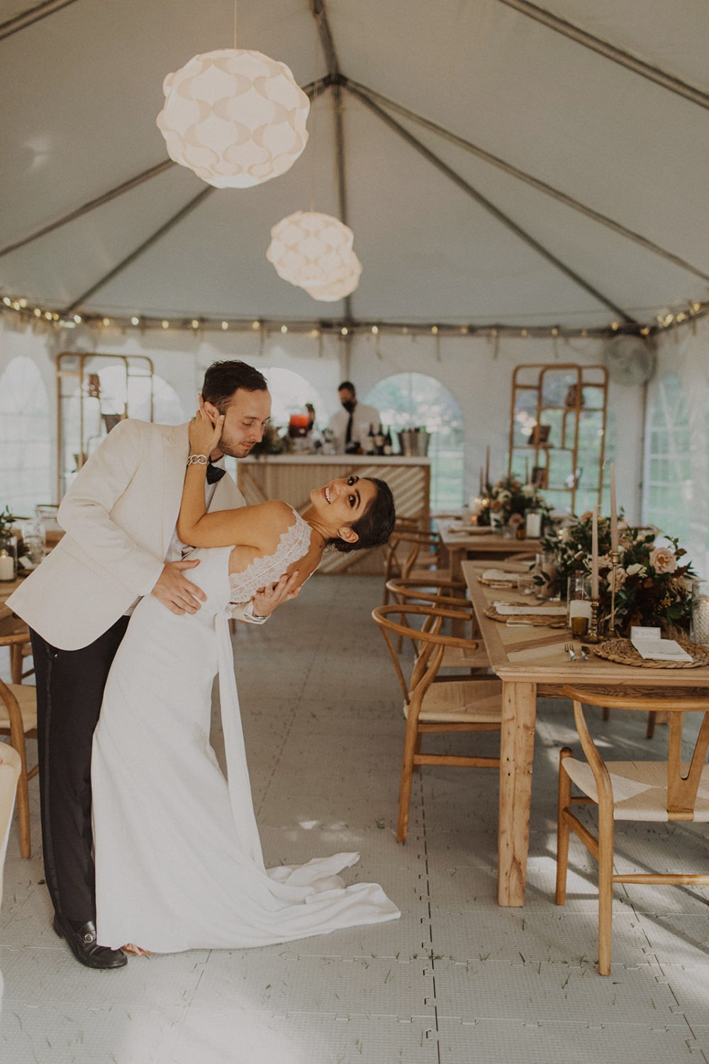 Couple embraces in tent reception 