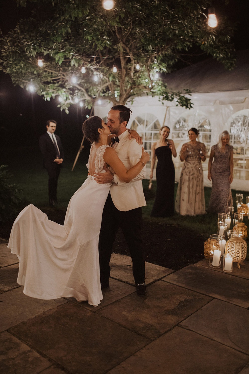 Couple kisses while dancing at backyard wedding