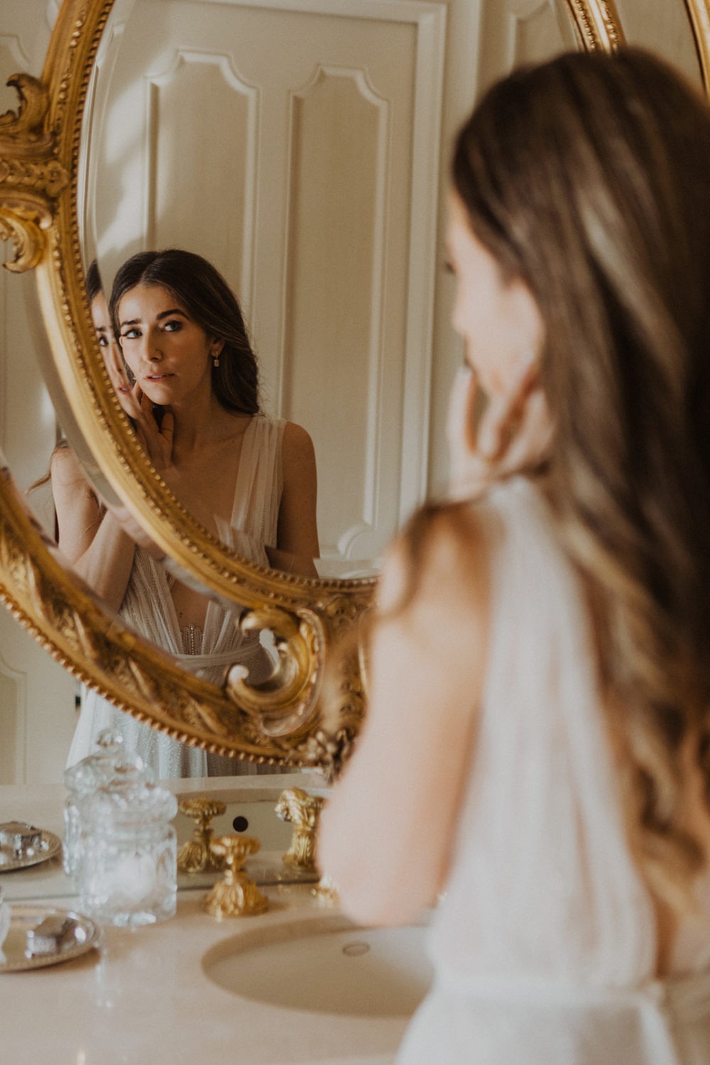 Bride getting ready in front of a mirror on the wedding morning 