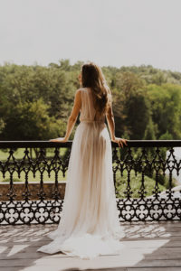 Bride looks out over wedding venue from porch
