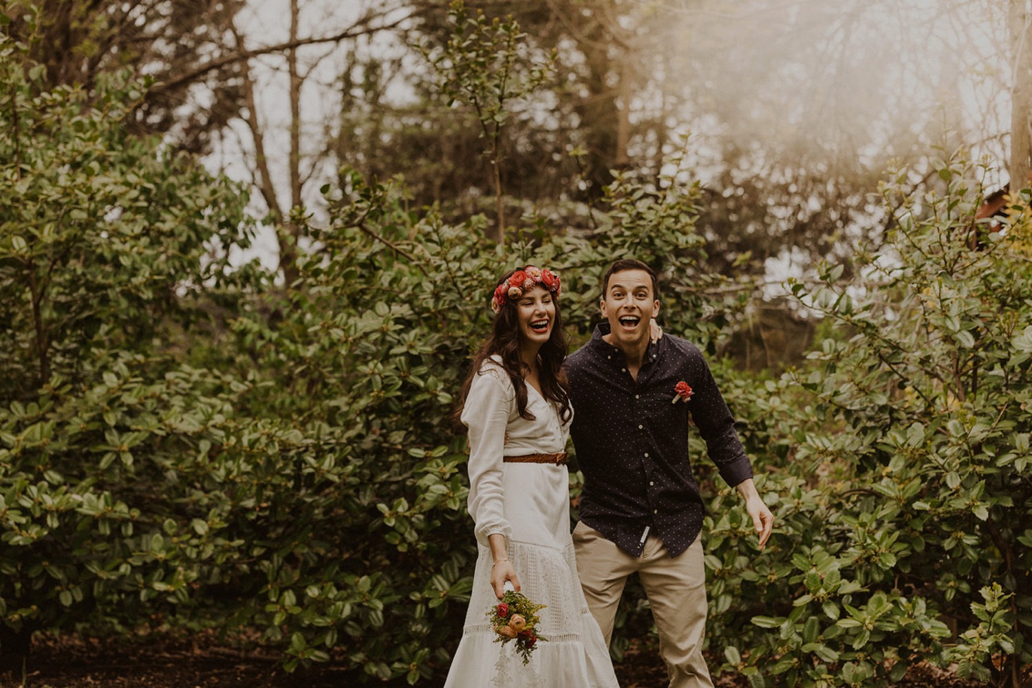 Couple laughs while holding spring wedding flowers