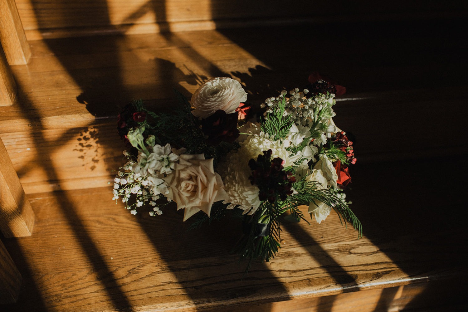 Wedding bouquet is set on steps in shadow and sunlight