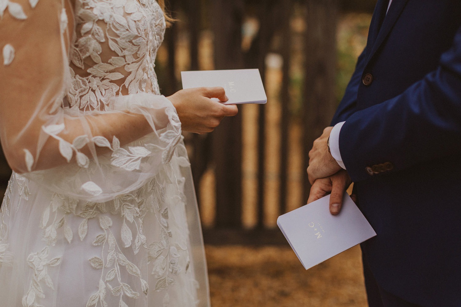 Couple holds wedding vow books at backyard wedding 