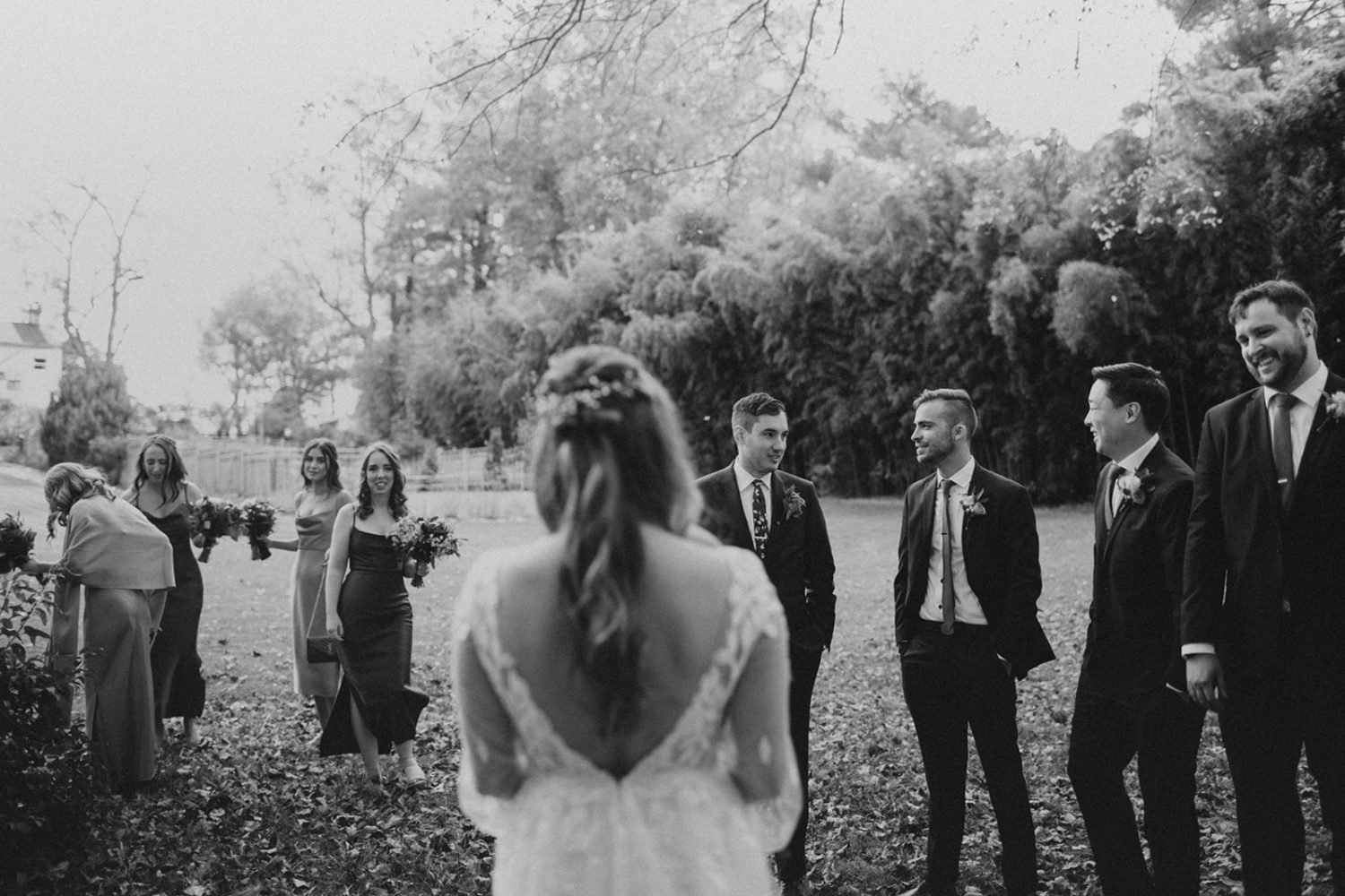 Couple stands with wedding party at backyard wedding 