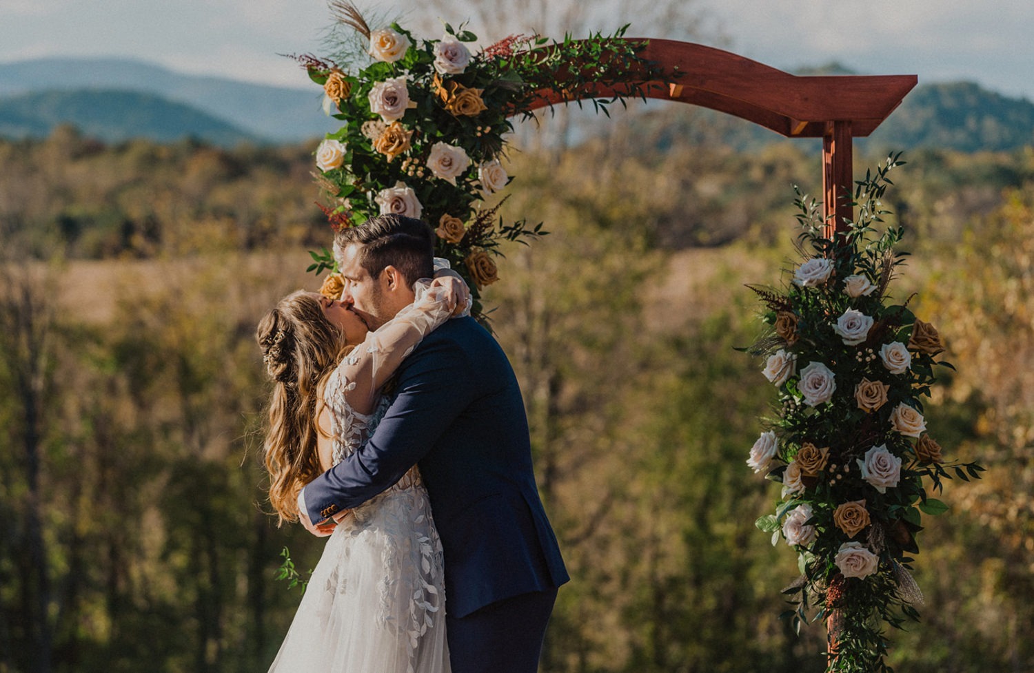 Couple kisses under arch at Virginia backyard wedding